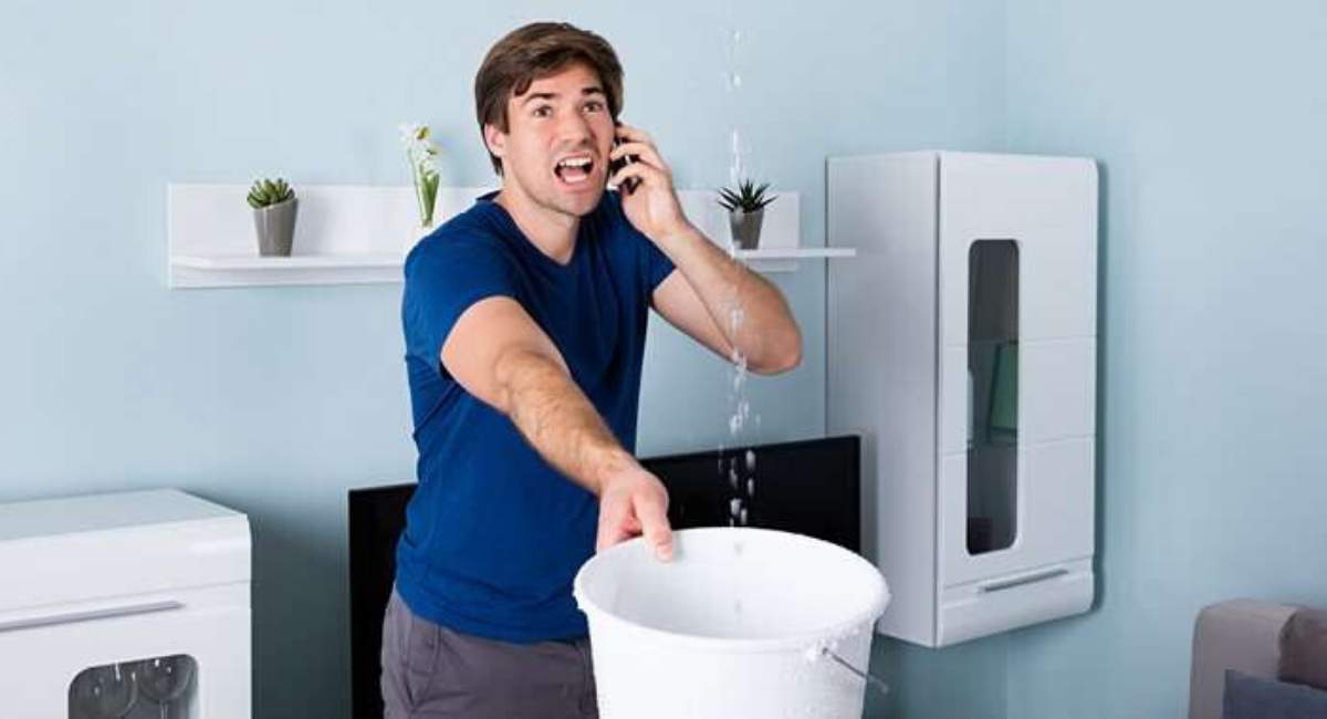 Man holding bucket for water leak