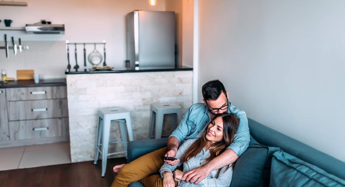 Couple using remote in living room