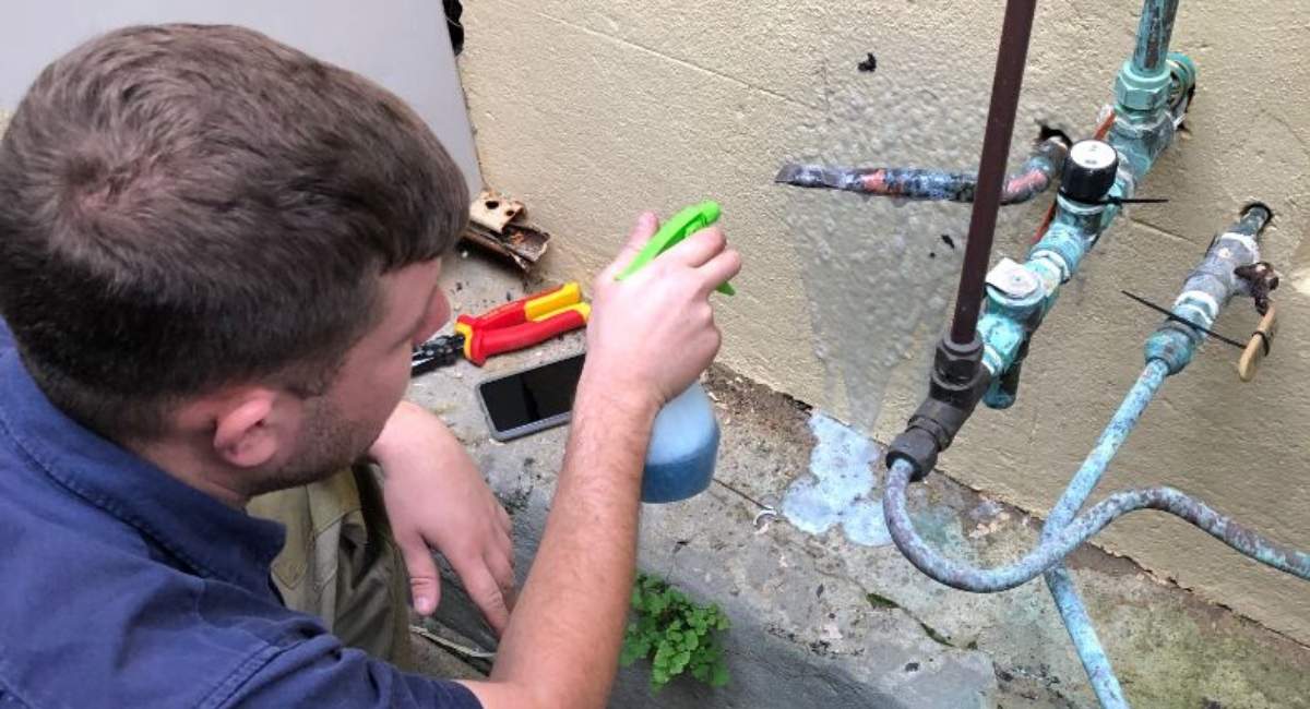 Man testing for leaks on pipes