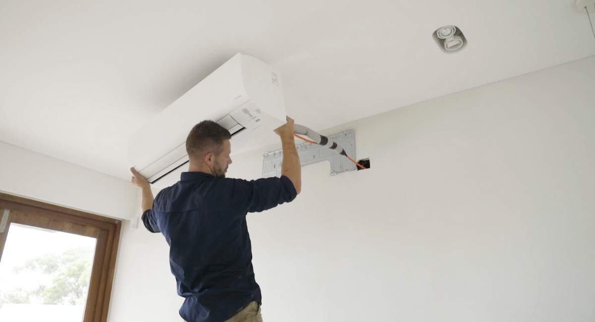 Man mounting air conditioning system