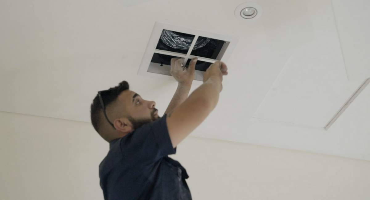 Man installing ducted air conditioning system