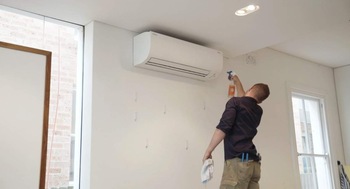 Man cleaning new wall mounted air conditioning system
