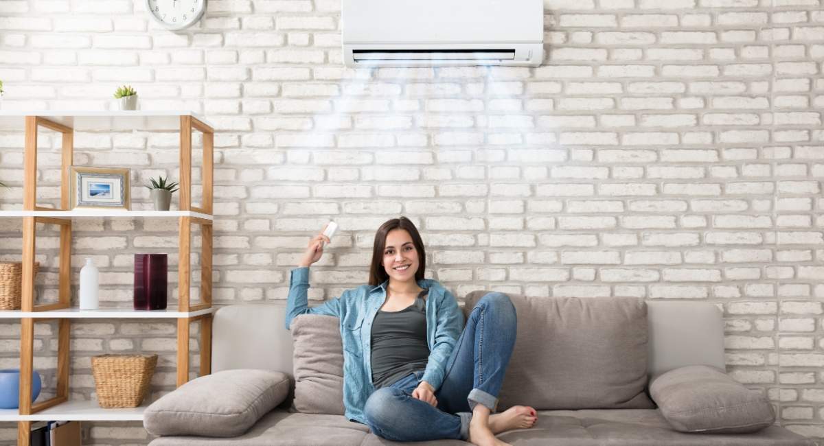 Woman sitting under wall air conditioning system